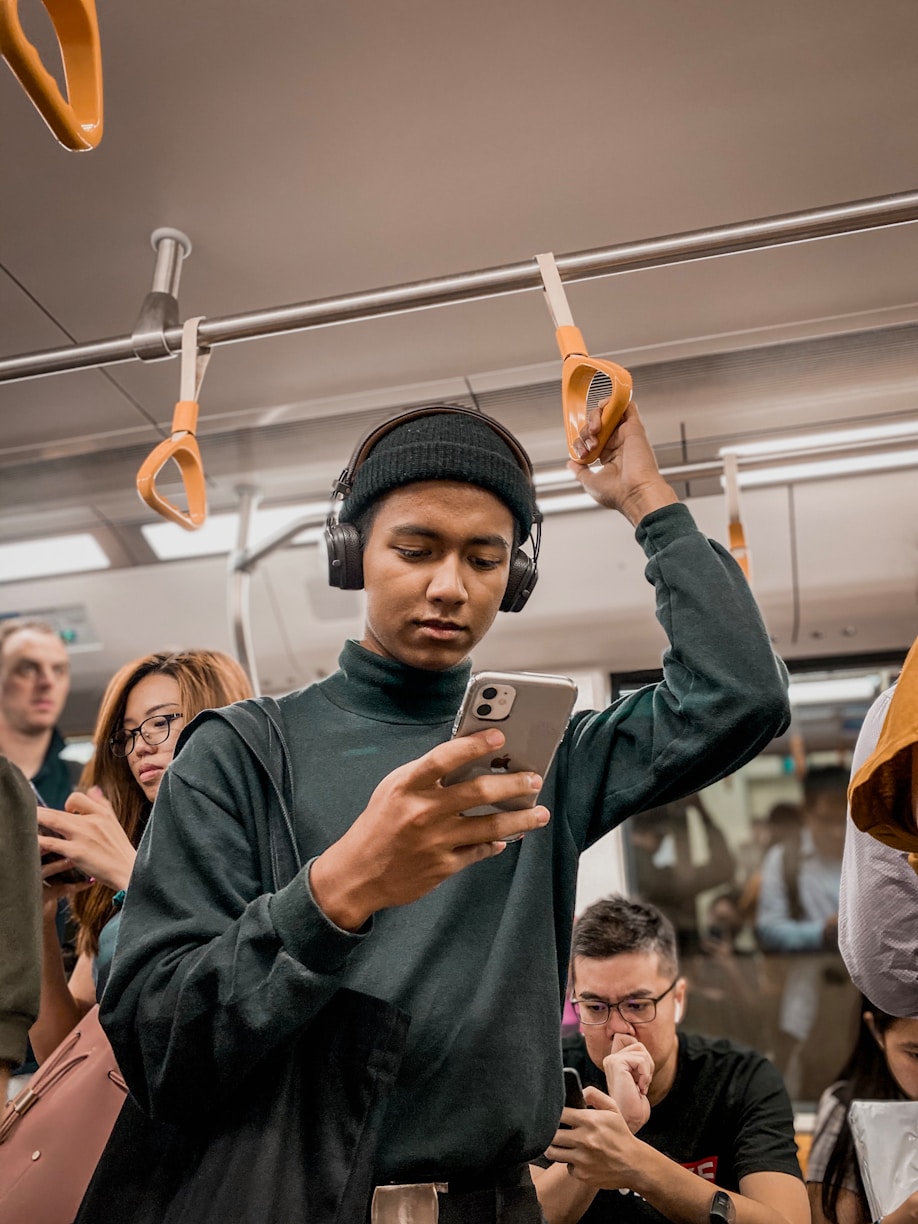Passenger standing on a train while checking a phone